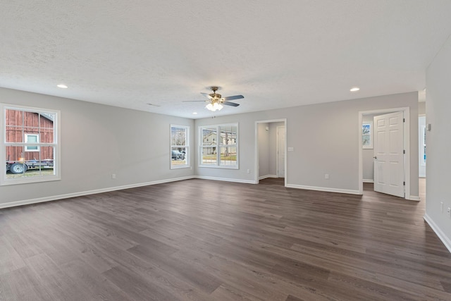 unfurnished living room with a textured ceiling, dark hardwood / wood-style flooring, plenty of natural light, and ceiling fan