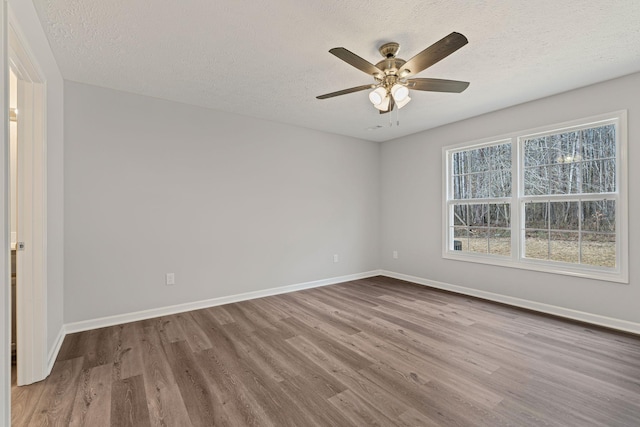 unfurnished room with ceiling fan, hardwood / wood-style floors, and a textured ceiling