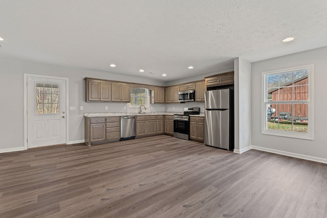 kitchen featuring a textured ceiling, stainless steel appliances, dark hardwood / wood-style floors, and sink