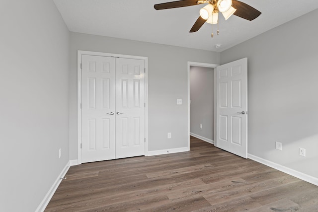 unfurnished bedroom with hardwood / wood-style flooring, ceiling fan, and a closet