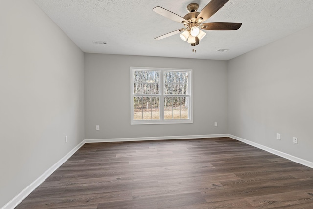 empty room with a textured ceiling, ceiling fan, and dark hardwood / wood-style floors