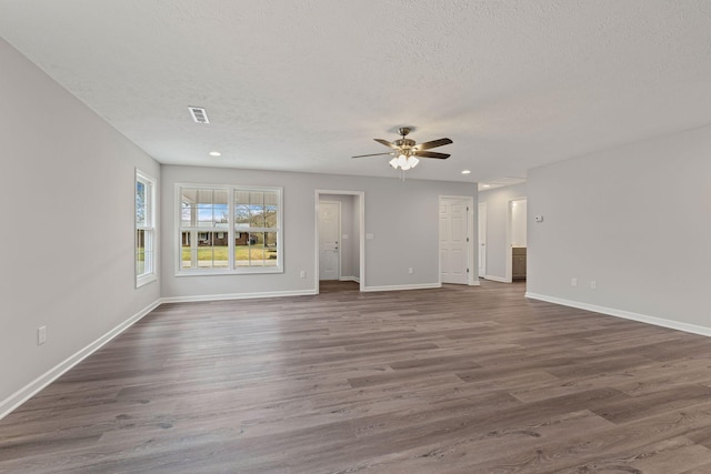 unfurnished living room featuring a textured ceiling, ceiling fan, and dark hardwood / wood-style floors