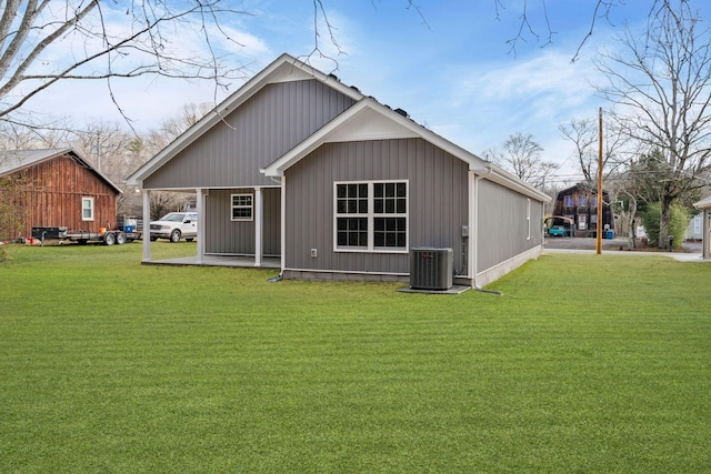 rear view of property featuring a lawn and central AC