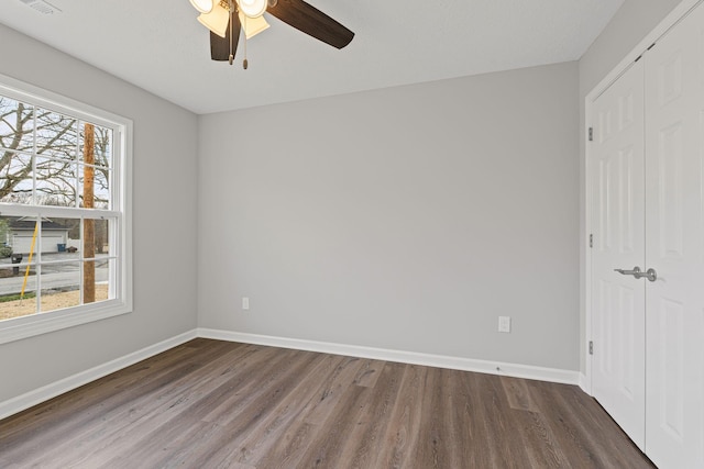 unfurnished bedroom featuring ceiling fan, a closet, and dark hardwood / wood-style floors