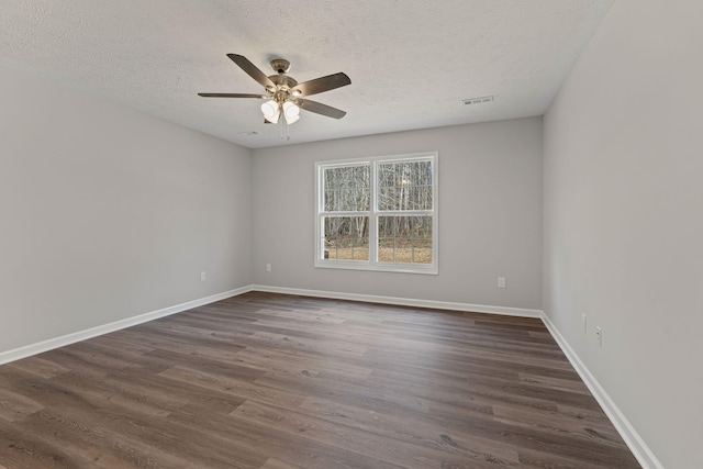 empty room featuring ceiling fan, a textured ceiling, and dark wood-type flooring