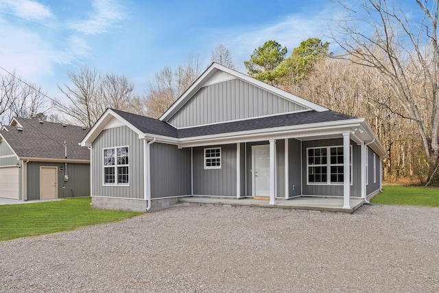 view of front facade with a front yard, a porch, and a garage