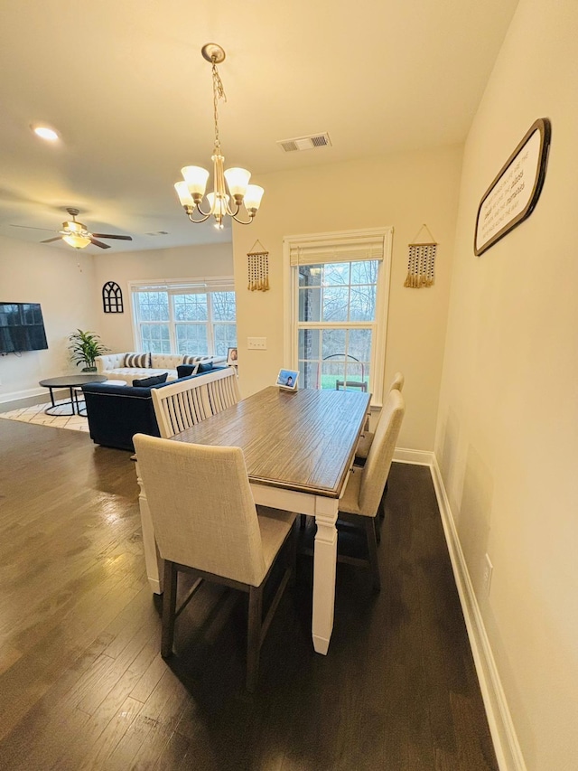 dining area with dark wood-type flooring and ceiling fan with notable chandelier