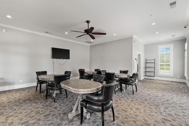 carpeted dining space with ceiling fan and ornamental molding