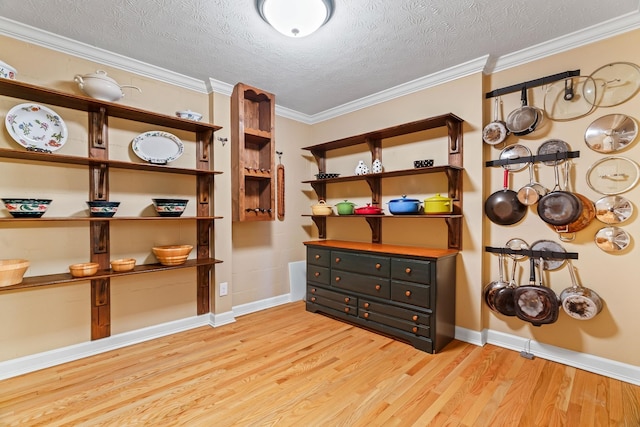 miscellaneous room featuring crown molding, light hardwood / wood-style floors, and a textured ceiling