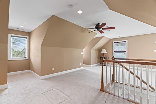 additional living space with ceiling fan, light colored carpet, and lofted ceiling