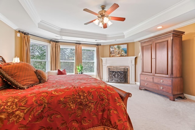 carpeted bedroom with ceiling fan, crown molding, and a tray ceiling