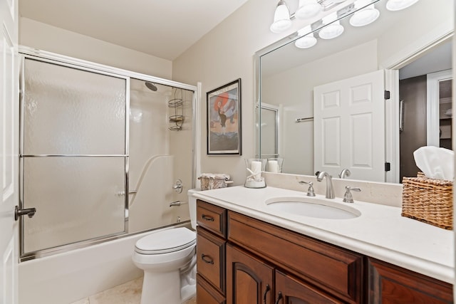 full bathroom featuring shower / bath combination with glass door, tile patterned flooring, vanity, and toilet