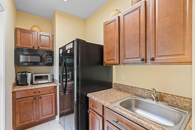 kitchen with sink, light tile patterned floors, and black appliances