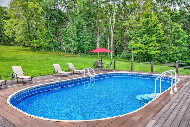 view of pool with a wooden deck and a yard