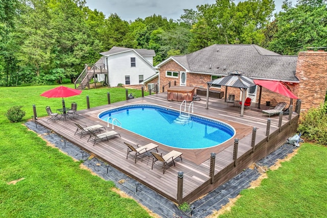 view of swimming pool featuring a gazebo, a yard, a wooden deck, and a hot tub