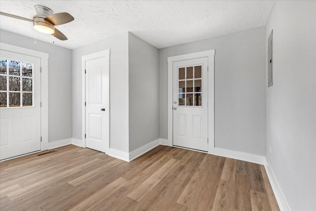 entrance foyer with baseboards, visible vents, ceiling fan, a textured ceiling, and light wood-type flooring