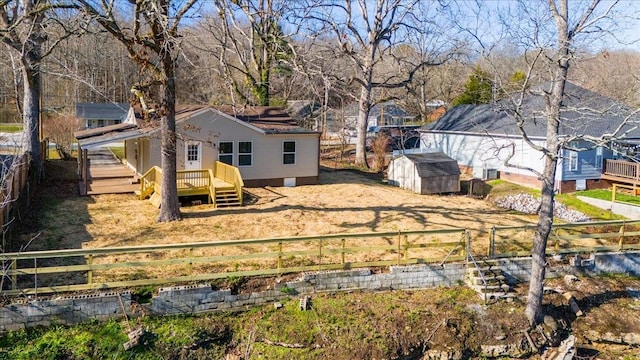 view of yard with a deck, an outbuilding, a storage unit, and a fenced backyard