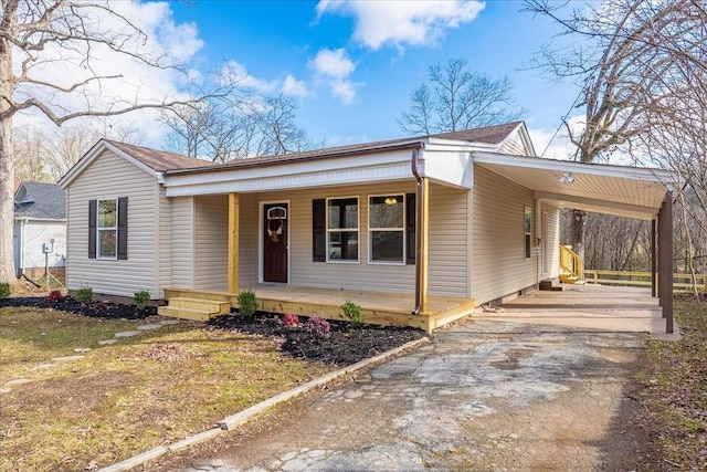 view of front of house featuring an attached carport, covered porch, and driveway