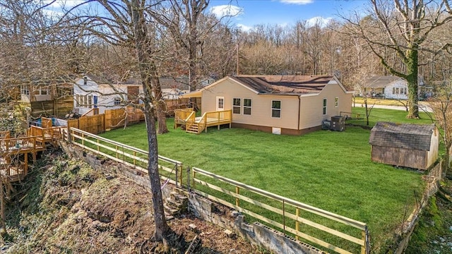 exterior space featuring a deck, an outdoor structure, a storage unit, and a lawn