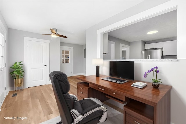 office area featuring light wood-style flooring, baseboards, and ceiling fan