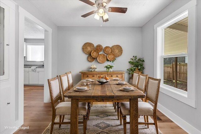 dining space with ceiling fan, baseboards, and wood finished floors