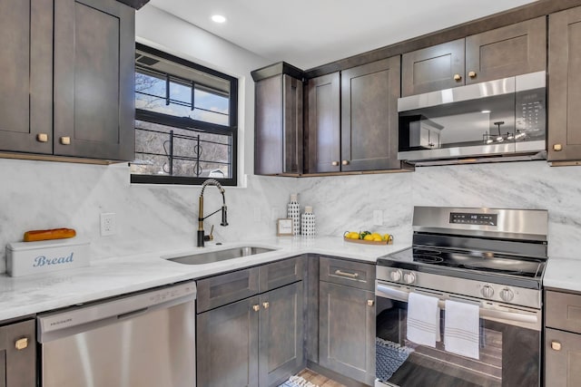 kitchen with tasteful backsplash, dark brown cabinetry, sink, and stainless steel appliances