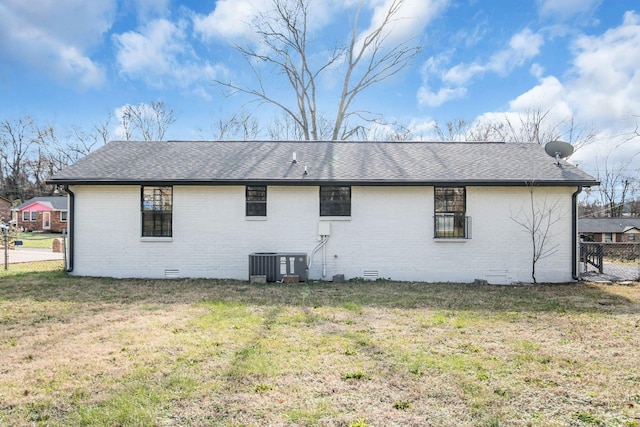 rear view of house featuring a lawn and central AC