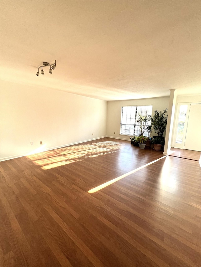 empty room with dark hardwood / wood-style flooring