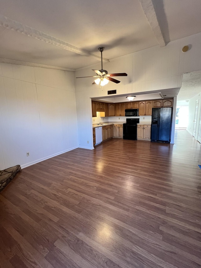 unfurnished living room featuring beam ceiling, dark hardwood / wood-style flooring, and ceiling fan