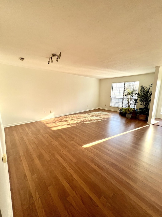 unfurnished room with wood-type flooring and rail lighting