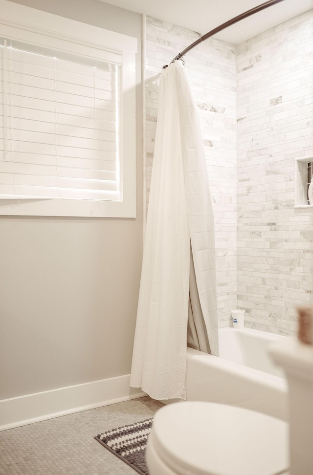 bathroom with toilet, shower / tub combo, and tile patterned floors