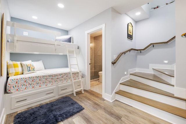 bedroom with light wood-type flooring and ensuite bathroom