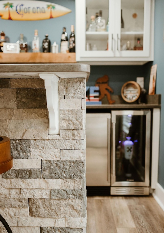 bar featuring wine cooler and light hardwood / wood-style flooring