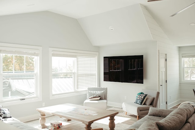 living room with light wood-type flooring, vaulted ceiling, and a healthy amount of sunlight