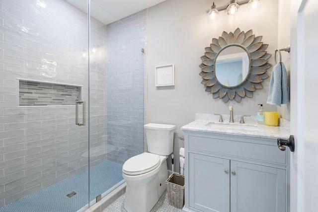 bathroom featuring vanity, toilet, and a shower with door