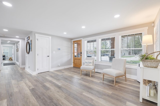 sitting room featuring baseboards, light wood-style flooring, and recessed lighting