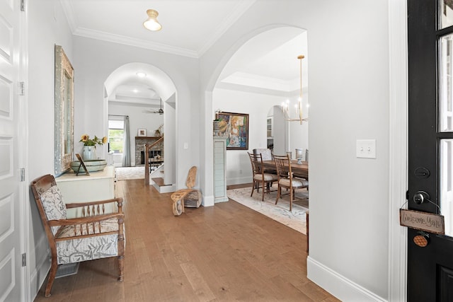 foyer featuring crown molding, ceiling fan with notable chandelier, and hardwood / wood-style flooring