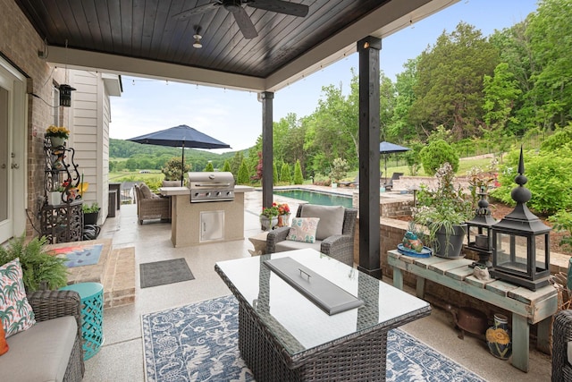 view of patio featuring area for grilling, ceiling fan, outdoor lounge area, and exterior kitchen