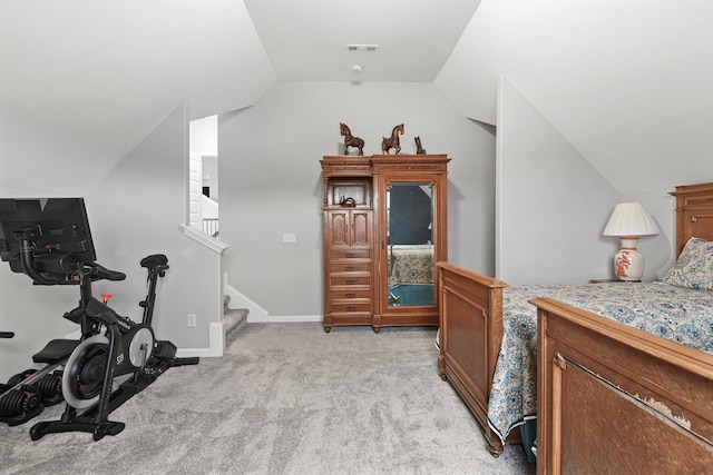 bedroom featuring light colored carpet and vaulted ceiling