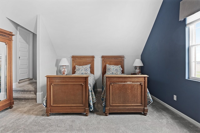 carpeted bedroom featuring multiple windows and lofted ceiling