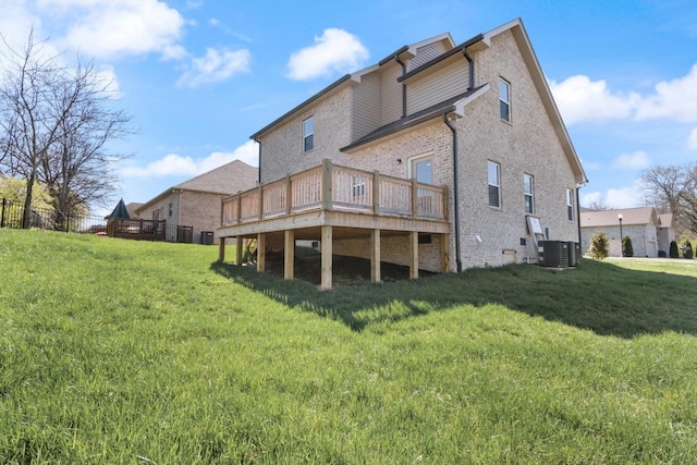 back of house with a deck, central AC unit, and a lawn