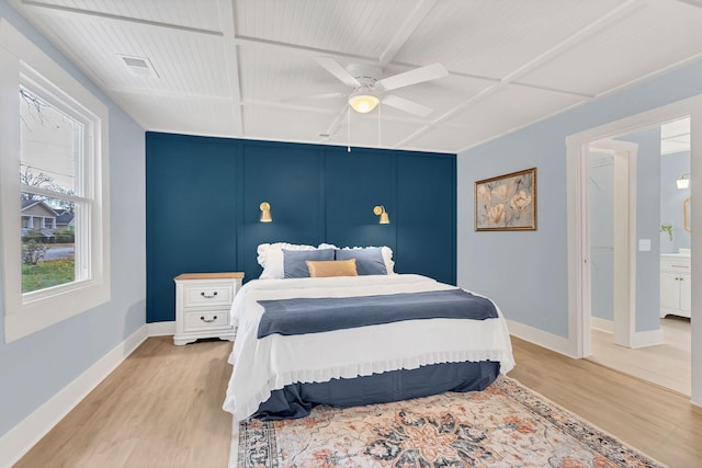 bedroom with visible vents, coffered ceiling, and light wood-style flooring