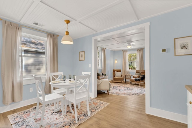 dining area with baseboards, visible vents, and wood finished floors