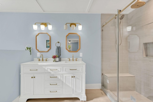 full bathroom featuring a sink, a shower stall, baseboards, and double vanity