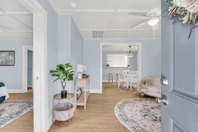 sitting room featuring light wood finished floors, visible vents, and baseboards