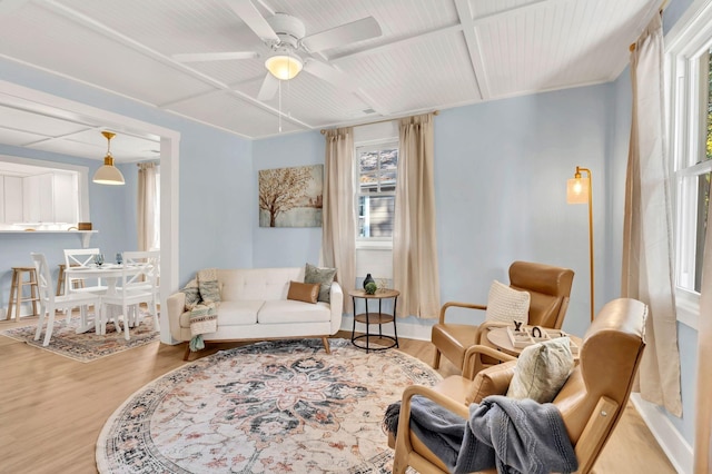 living room featuring a ceiling fan, coffered ceiling, and wood finished floors