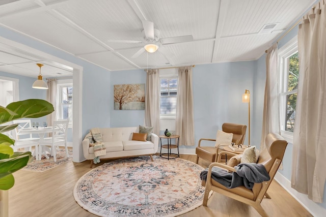 living area featuring plenty of natural light, wood finished floors, and a ceiling fan