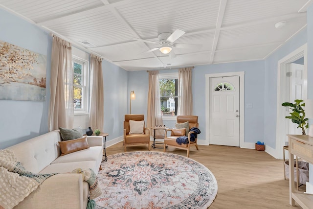 living area featuring light wood finished floors, plenty of natural light, and baseboards