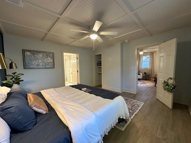 bedroom featuring coffered ceiling, wood finished floors, a ceiling fan, visible vents, and baseboards