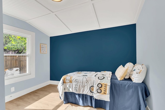 bedroom featuring baseboards, vaulted ceiling, and wood finished floors